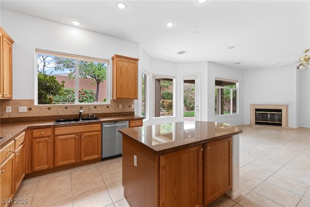 kitchen featuring stainless steel dishwasher, a sink, recessed lighting, and a healthy amount of sunlight