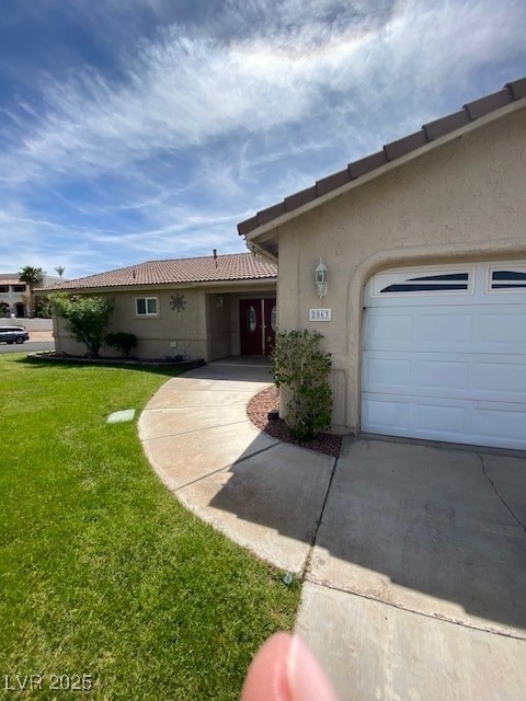 view of front of home featuring an attached garage, a front yard, and stucco siding