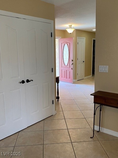 entrance foyer with baseboards and light tile patterned floors