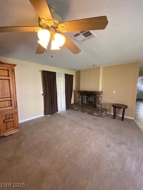 unfurnished living room featuring a glass covered fireplace, visible vents, baseboards, a ceiling fan, and carpet floors