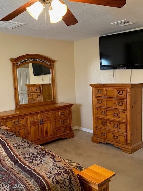 bedroom with light colored carpet, ceiling fan, and visible vents
