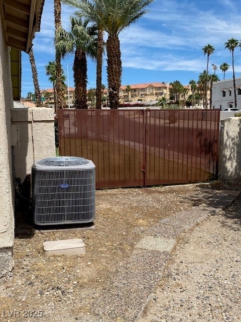 view of yard with central AC, fence, and a residential view
