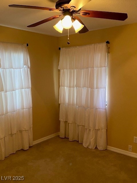 unfurnished room with carpet flooring, baseboards, and a ceiling fan