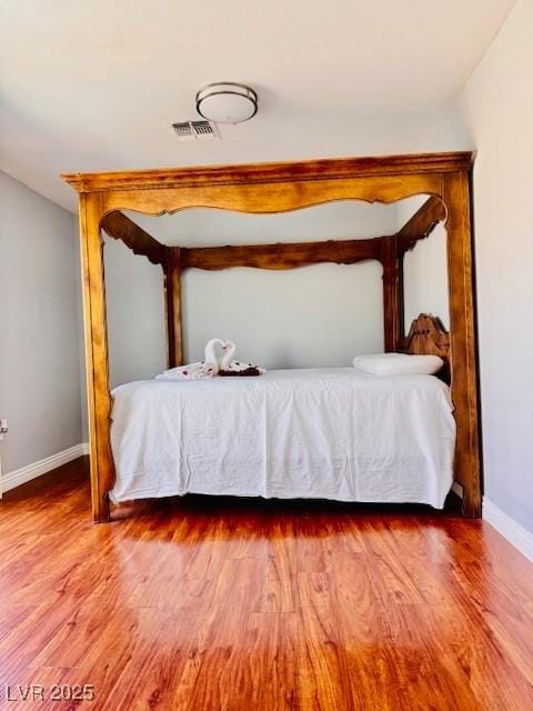 6786 Grandola Dr, Las Vegas, NV 89103 - bedroom featuring wood finished floors, visible vents, and baseboards