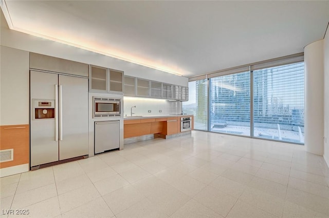 3726 S Las Vegas Blvd Unit 1003, Las Vegas, NV 89158 - kitchen with built in appliances, a sink, expansive windows, light countertops, and glass insert cabinets