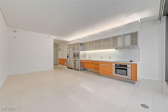 3726 S Las Vegas Blvd Unit 1003, Las Vegas, NV 89158 - kitchen featuring stainless steel appliances, a sink, glass insert cabinets, light countertops, and baseboards