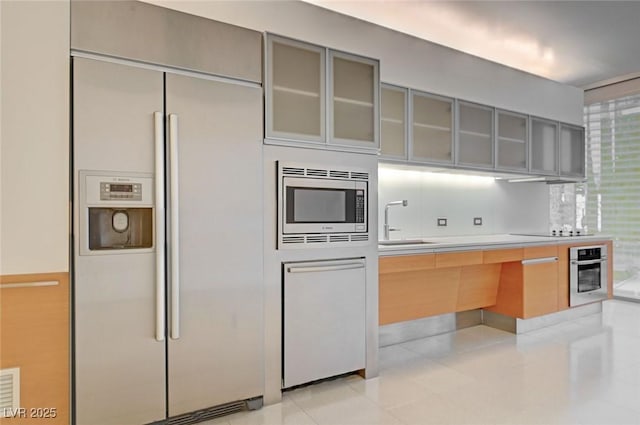 3726 S Las Vegas Blvd Unit 1003, Las Vegas, NV 89158 - kitchen featuring built in appliances, gray cabinets, a sink, and glass insert cabinets