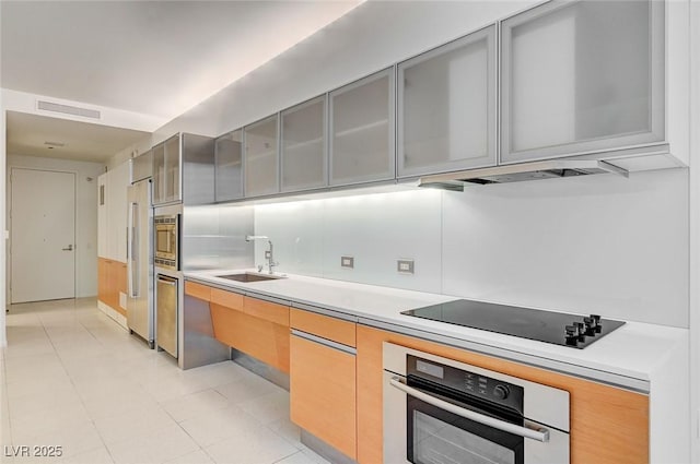 3726 S Las Vegas Blvd Unit 1003, Las Vegas, NV 89158 - kitchen featuring stainless steel appliances, a sink, light countertops, gray cabinets, and glass insert cabinets