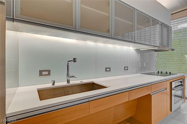 3726 S Las Vegas Blvd Unit 1003, Las Vegas, NV 89158 - kitchen featuring stainless steel oven, black electric stovetop, light countertops, glass insert cabinets, and decorative backsplash