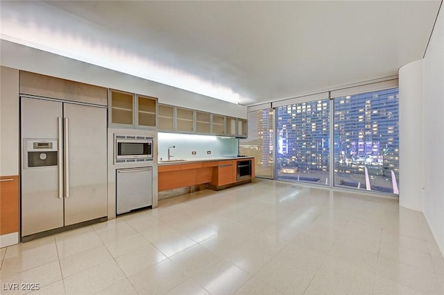3726 S Las Vegas Blvd Unit 1003, Las Vegas, NV 89158 - kitchen with built in appliances, a sink, glass insert cabinets, and light countertops