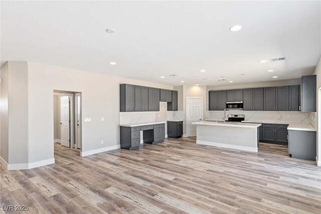 790 Lone Pine Rd, Pahrump, NV 89048 - kitchen with stainless steel microwave, gray cabinets, light wood-style floors, backsplash, and recessed lighting