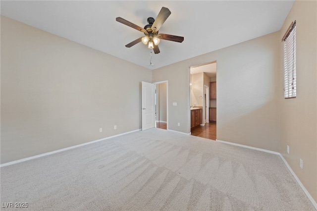 unfurnished bedroom with connected bathroom, ceiling fan, baseboards, and carpet