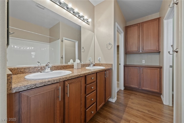 10664 Mount Jefferson Ave, Las Vegas, NV 89166 - bathroom featuring double vanity, wood finished floors, baseboards, and a shower