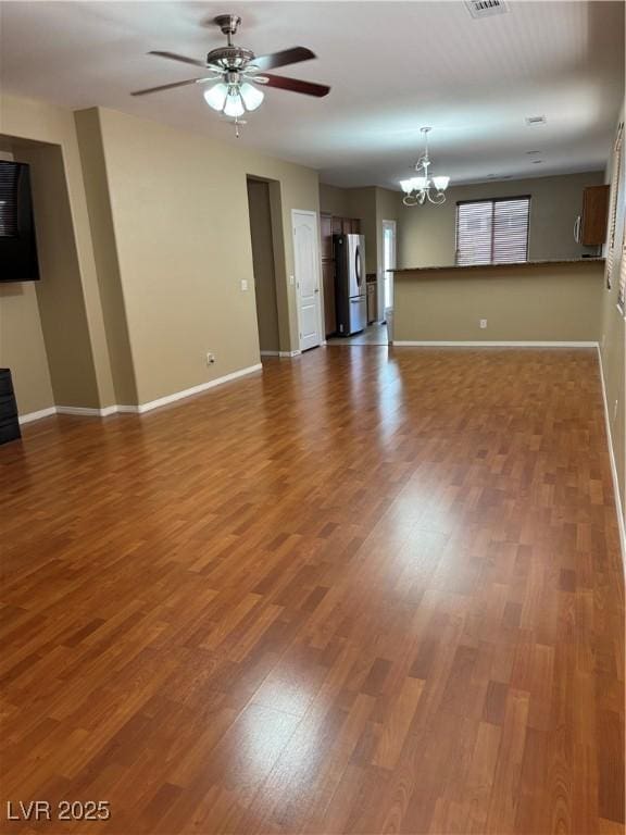 10664 Mount Jefferson Ave, Las Vegas, NV 89166 - unfurnished living room featuring a chandelier, baseboards, and wood finished floors