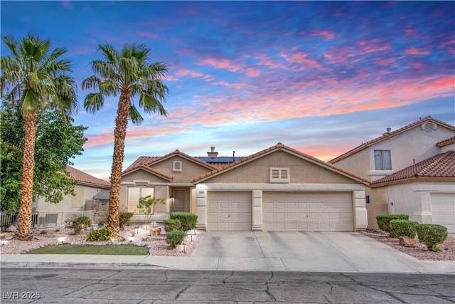 1552 Livingston Dr, Henderson, NV 89012 - view of front of home with an attached garage, stucco siding, a tile roof, driveway, and roof mounted solar panels