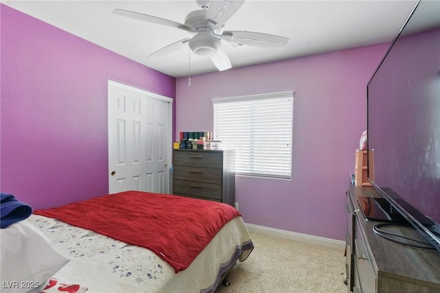 bedroom with a closet, a ceiling fan, baseboards, and light carpet