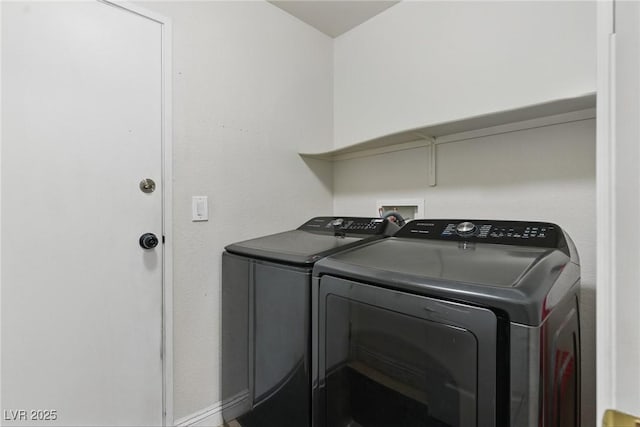 washroom featuring separate washer and dryer, baseboards, and laundry area