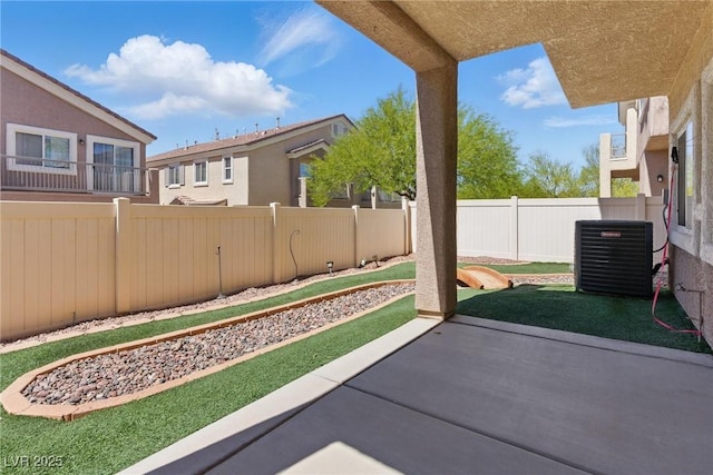 view of yard with a fenced backyard, central air condition unit, and a patio