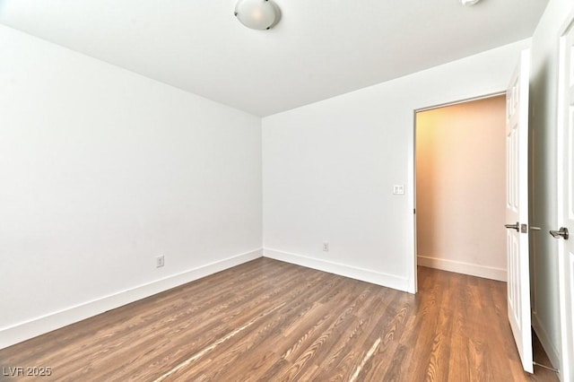 empty room featuring baseboards and wood finished floors