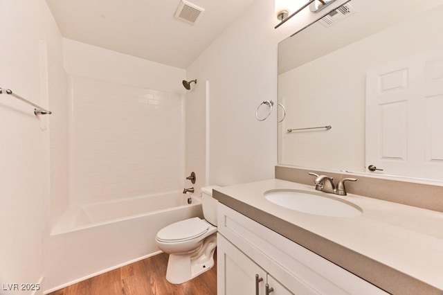 bathroom featuring wood finished floors, vanity, shower / washtub combination, toilet, and visible vents