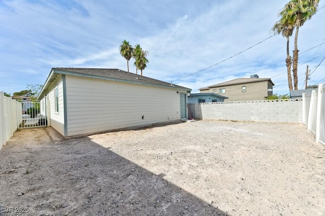 rear view of house featuring a fenced backyard