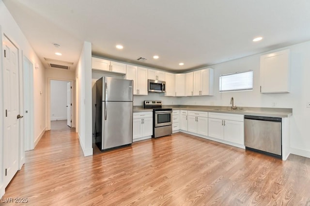 kitchen with visible vents, a sink, white cabinetry, and appliances with stainless steel finishes
