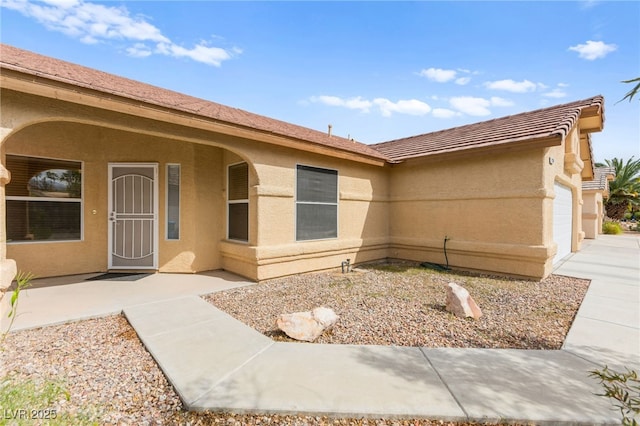 5224 Dana Springs Way, Las Vegas, NV 89130 - property entrance featuring stucco siding, a tile roof, and a garage