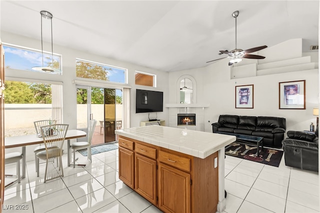 5224 Dana Springs Way, Las Vegas, NV 89130 - kitchen with tile counters, vaulted ceiling, light tile patterned floors, a tiled fireplace, and ceiling fan