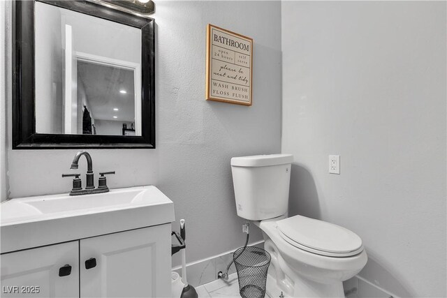 5208 Overland Ave, Las Vegas, NV 89107 - bathroom with baseboards, marble look tiles, toilet, and vanity