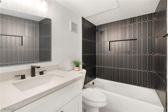 bathroom featuring shower / bathing tub combination, vanity, a textured wall, toilet, and visible vents