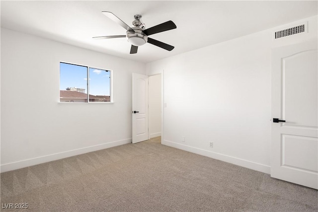 empty room featuring baseboards, visible vents, and light colored carpet