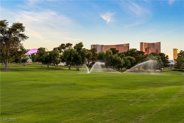 surrounding community featuring a lawn and view of golf course