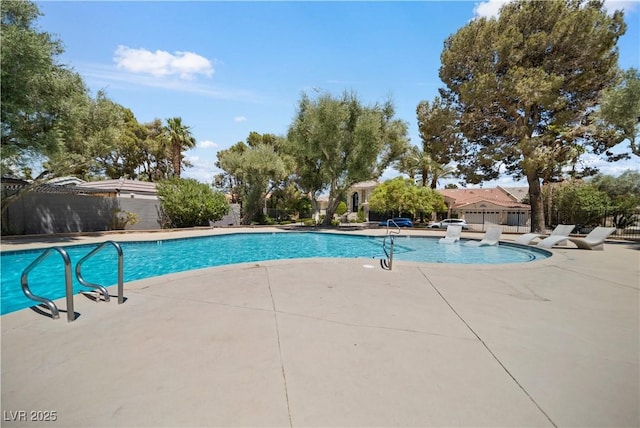 community pool featuring a fenced backyard and a patio area
