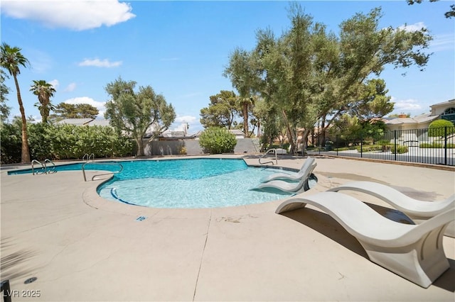 community pool with fence and a patio area