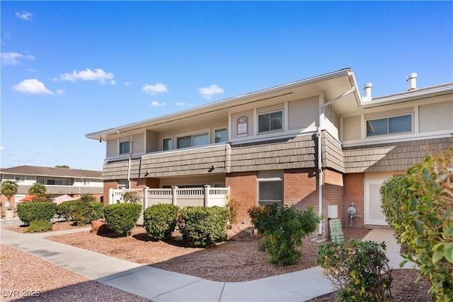 exterior space featuring fence and brick siding