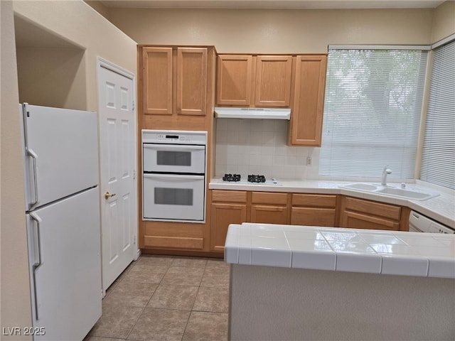 9324 Pitching Wedge Dr, Las Vegas, NV 89134 - kitchen featuring white appliances, a sink, tile counters, and decorative backsplash
