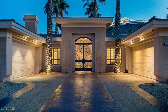 1665 Liege Dr, Henderson, NV 89012 - entrance to property featuring concrete driveway, a chimney, stucco siding, and a garage
