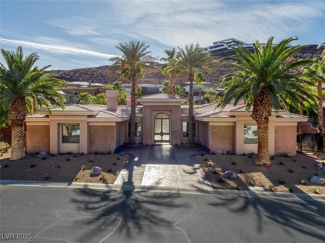 1665 Liege Dr, Henderson, NV 89012 - mediterranean / spanish house with an attached garage, driveway, a mountain view, and stucco siding