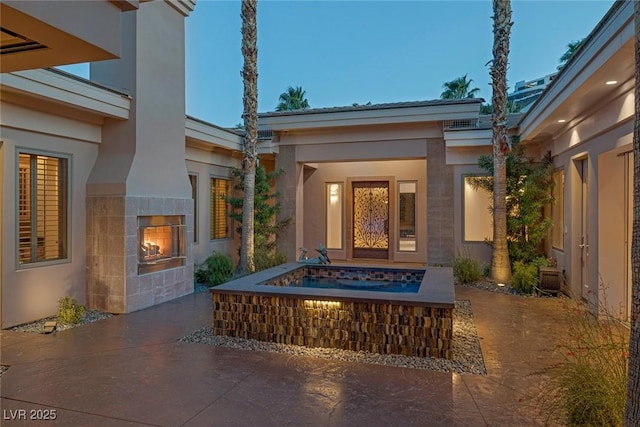 1665 Liege Dr, Henderson, NV 89012 - exterior space with stucco siding, a tile fireplace, and a patio
