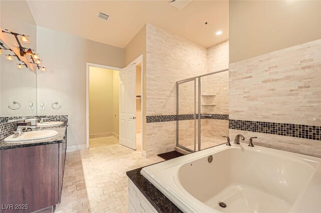 2455 W Serene Ave Unit 923, Las Vegas, NV 89123 - full bathroom with a garden tub, double vanity, tiled shower, and tile walls