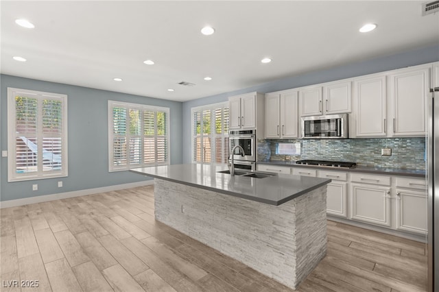 11784 Golden Moments Ave, Las Vegas, NV 89138 - kitchen with light wood-style floors, decorative backsplash, stainless steel appliances, and a sink