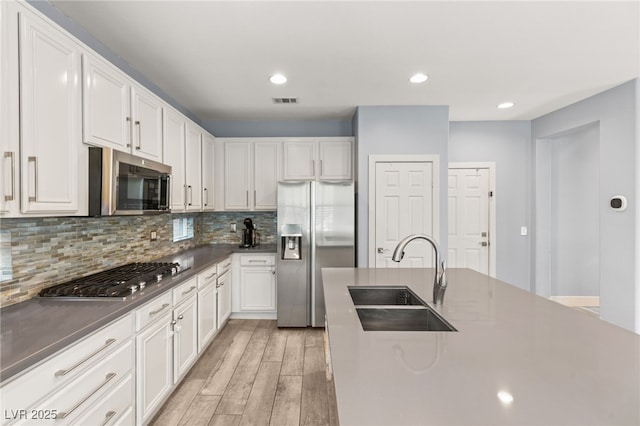 11784 Golden Moments Ave, Las Vegas, NV 89138 - kitchen with dark countertops, light wood-style flooring, stainless steel appliances, and a sink