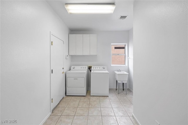 laundry area featuring baseboards, visible vents, washer and clothes dryer, and cabinet space