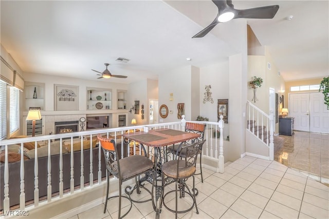 8942 Galena Crossing St, Las Vegas, NV 89123 - dining room featuring ceiling fan, healthy amount of natural light, a tiled fireplace, and light tile patterned floors
