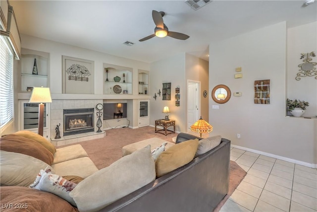 8942 Galena Crossing St, Las Vegas, NV 89123 - living area with ceiling fan, built in features, a tiled fireplace, baseboards, and light tile patterned floors