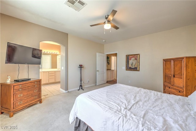 8942 Galena Crossing St, Las Vegas, NV 89123 - bedroom with light colored carpet, arched walkways, connected bathroom, a ceiling fan, and light tile patterned floors