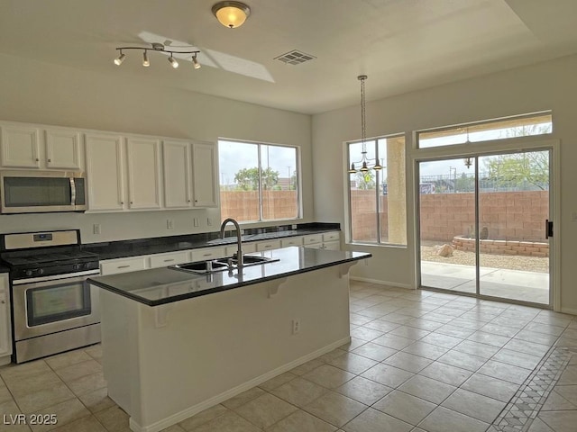 825 Happy Sparrow Ave, Henderson, NV 89052 - kitchen with dark countertops, a sink, light tile patterned flooring, stainless steel appliances, and visible vents