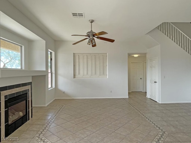 825 Happy Sparrow Ave, Henderson, NV 89052 - unfurnished living room featuring visible vents, a ceiling fan, baseboards, and a tile fireplace