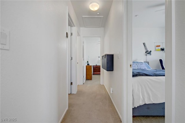 hallway with baseboards and light carpet