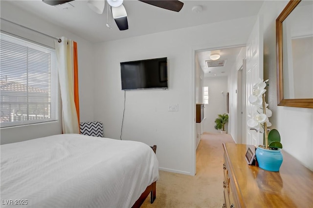 bedroom with light colored carpet, a ceiling fan, visible vents, and baseboards